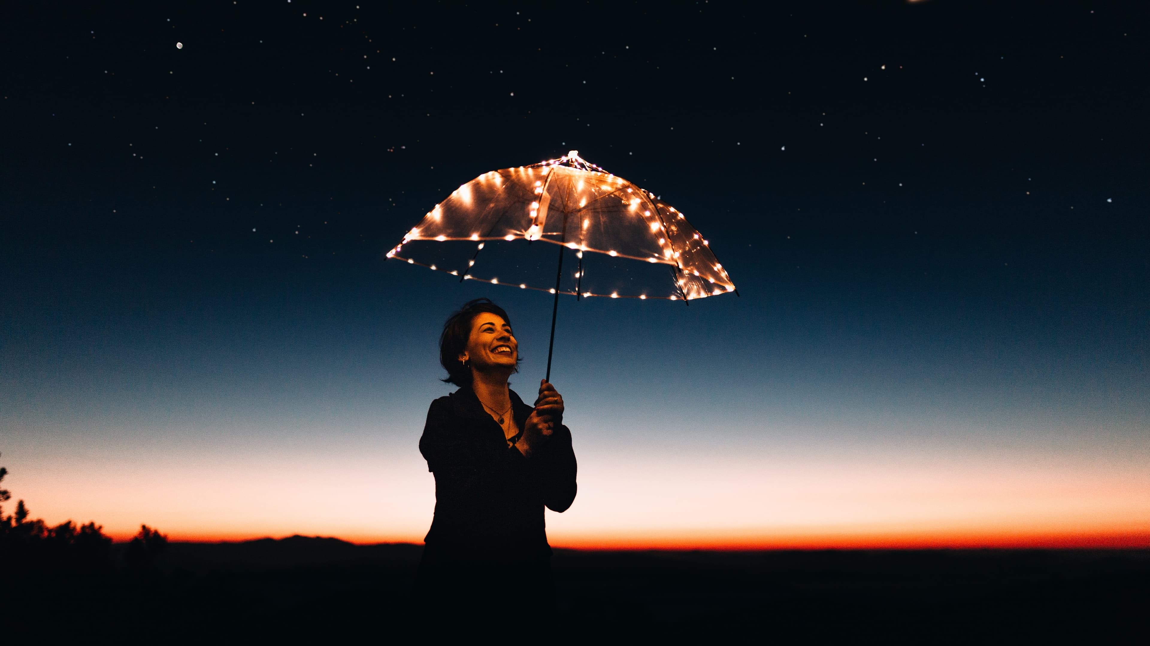 a girl holding an umbrella with lights